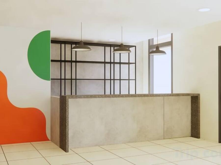 Un espace d’accueil avec un comptoir de réception, des luminaires suspendus et une porte sur le côté droit.