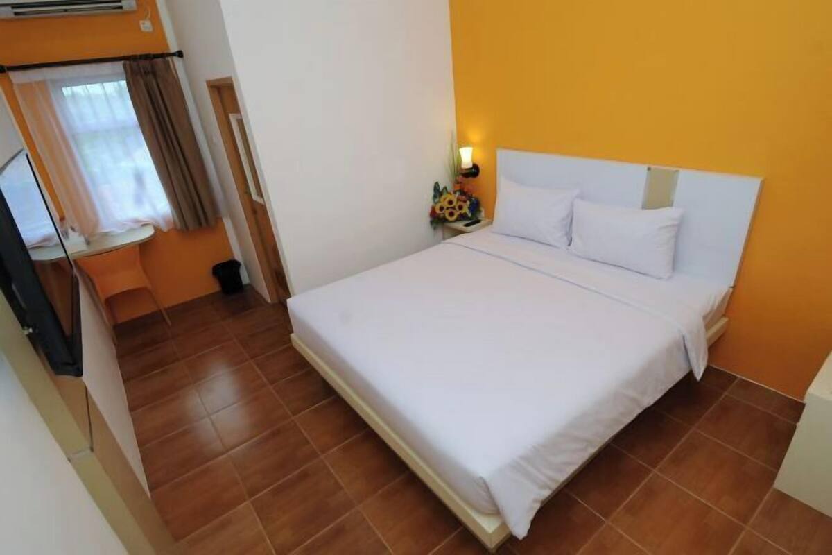 Une chambre d’hôtel avec un lit, un bureau et une chaise.