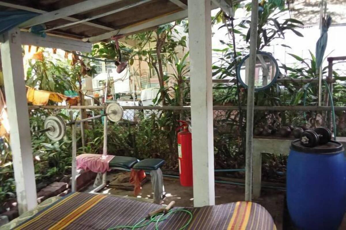 A covered outdoor area with a bench, a fire extinguisher, and exercise equipment.