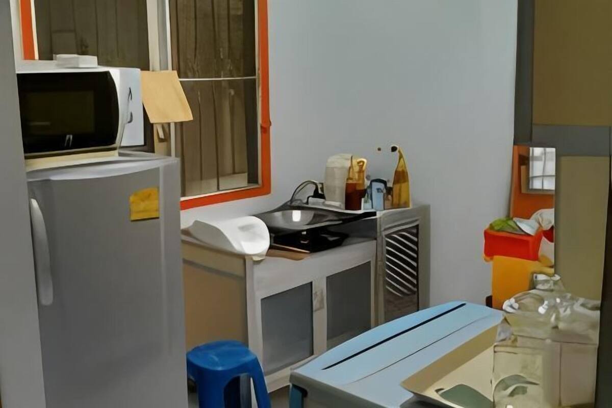 A compact kitchen with a microwave, sink, and a small dining area.