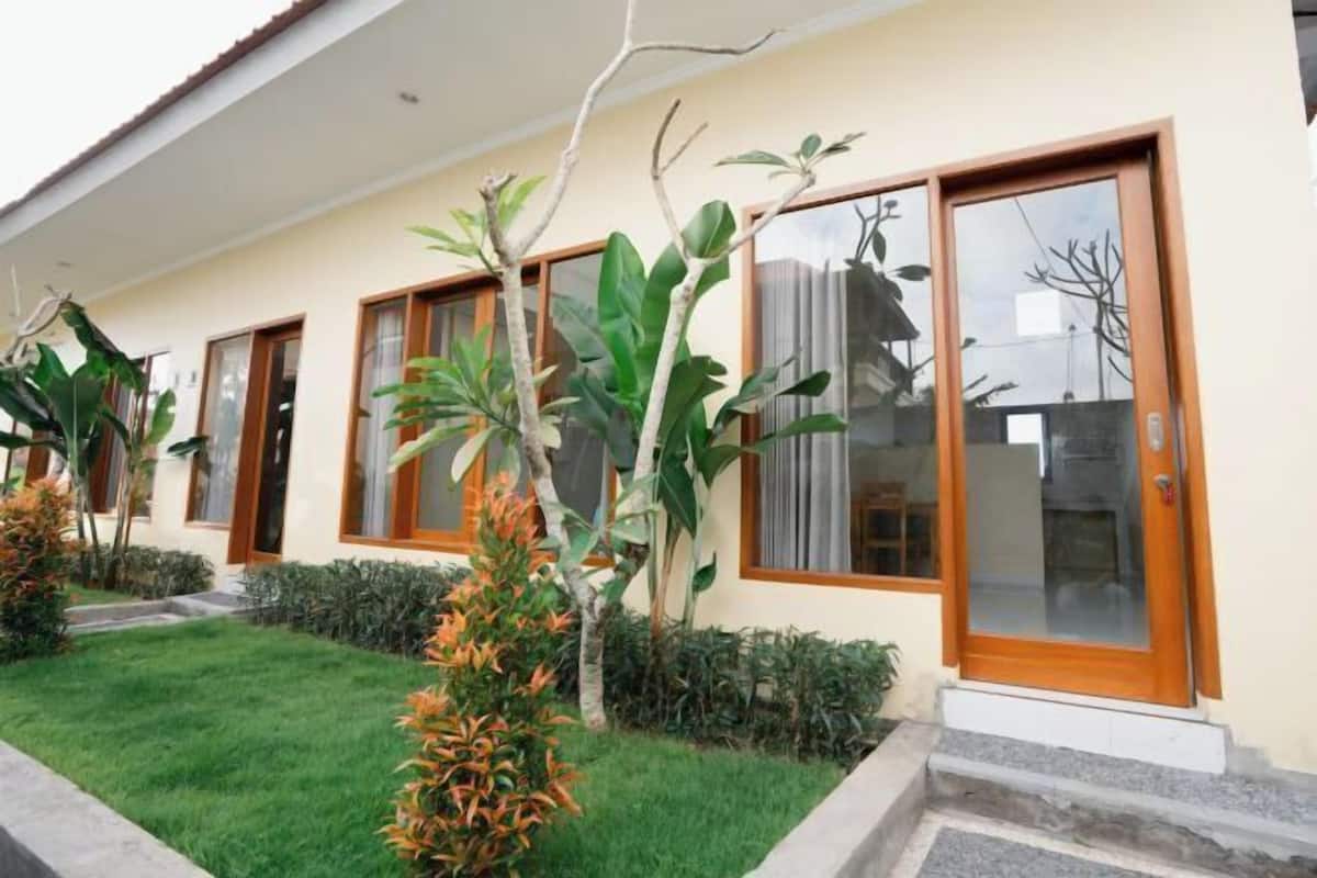 A modern house with a well-maintained lawn, large windows, and a wooden door.