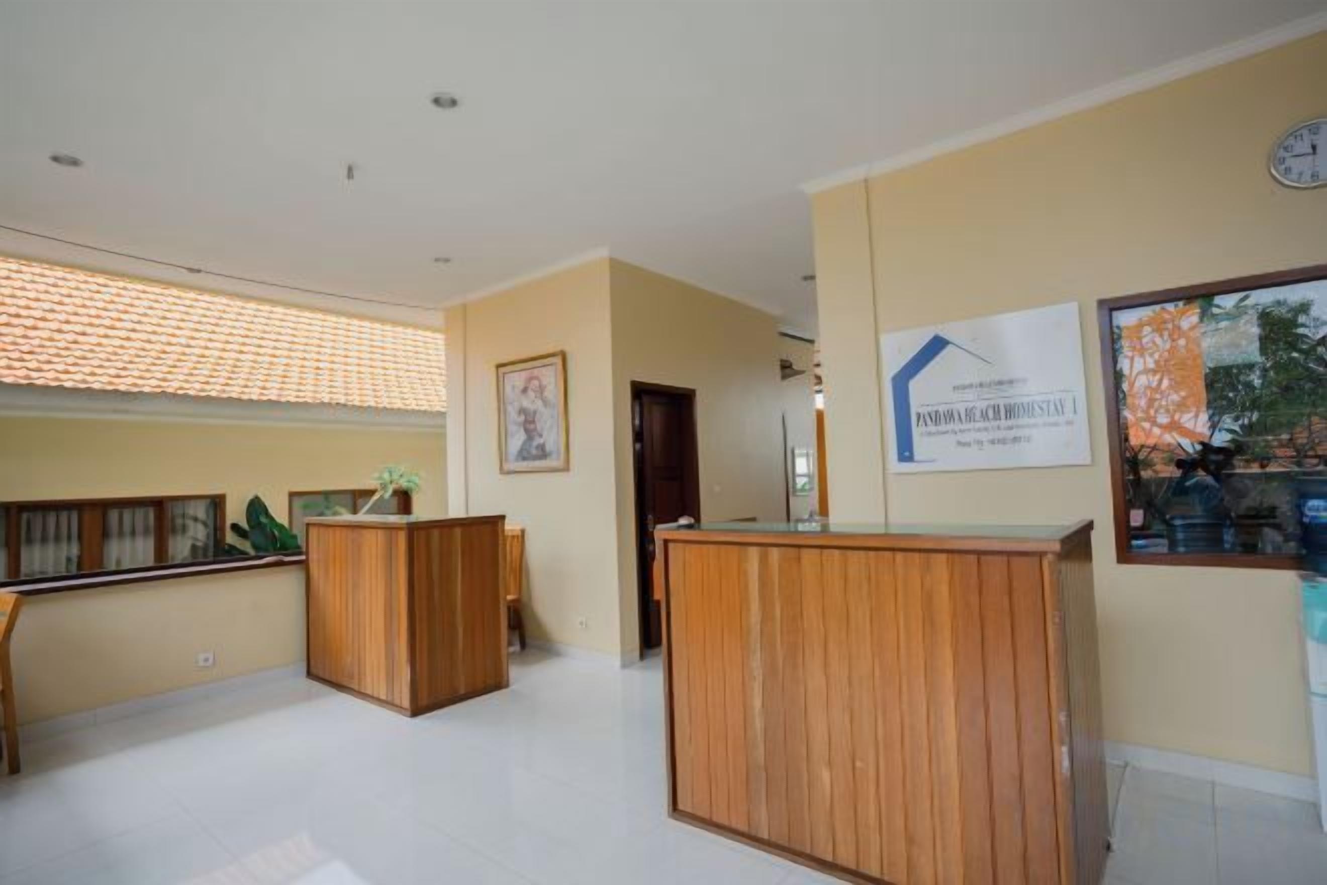 A reception area with wooden reception desks, a framed certificate on the wall, and a window with a view of trees.
