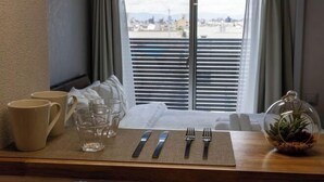 A dining table set with a placemat, cutlery, and a glass. - Bainan Service Apartment (Osaka)