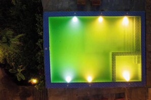 A rectangular pool with a blue border and four lights at the corners.