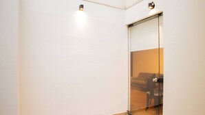 A room with a glass door leading to a living area, a tiled floor, and two wall-mounted lights. - w Stylish Bright 2BR in Miraflores (Lima)