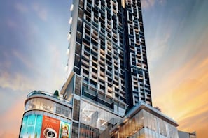 A high-rise building with a curved glass facade, multiple balconies, and a prominent advertisement on the lower level. - The Alfa Bangsar by City Keys (Kuala Lumpur)