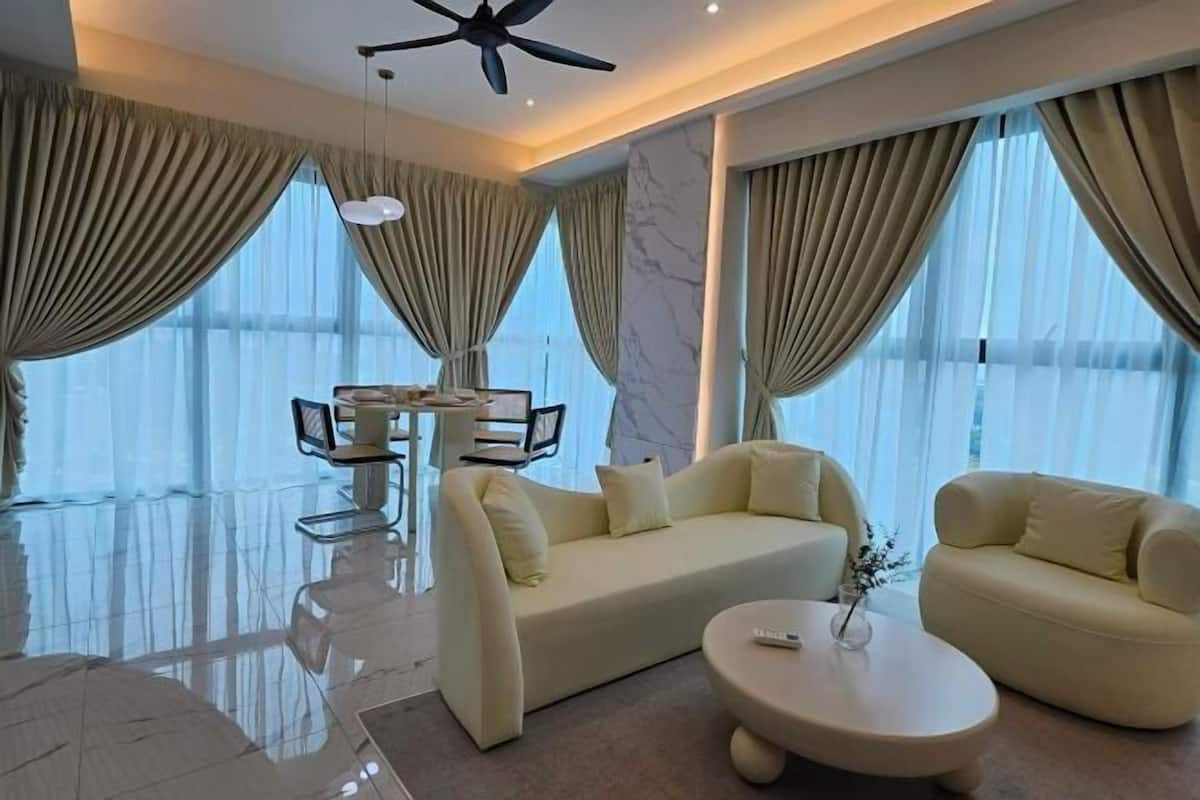 A modern living room with a sofa, coffee table, and dining area.