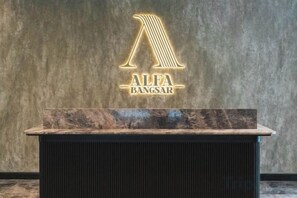 A reception desk with a marble top and a logo for 'ALFA BANGSAR' on the wall behind it. - The Alfa Bangsar by City Keys (Kuala Lumpur)