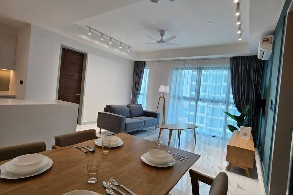 A modern living room with a dining area, a sofa, a small table, and a ceiling fan.