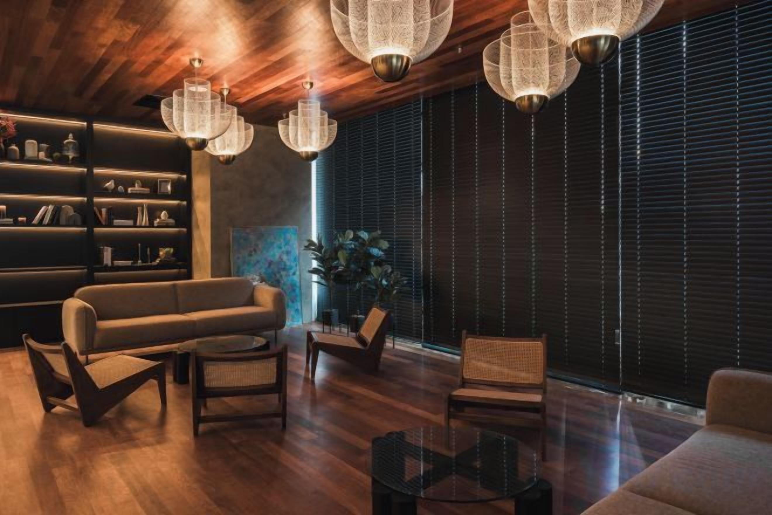 Una sala de estar moderna con techo de madera, un sofá, sillas, una mesa de centro y una estantería.