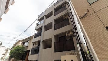 A multi-story residential building with balconies and air conditioning units.