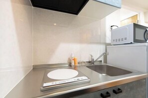 A kitchen with a microwave, sink, and digital scale. - Repure Higashimukojima Ekimae Residence II (Tokyo)