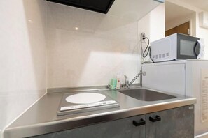 A kitchen with a digital scale, a microwave, and a sink. - Repure Higashimukojima Ekimae Residence II (Tokyo)