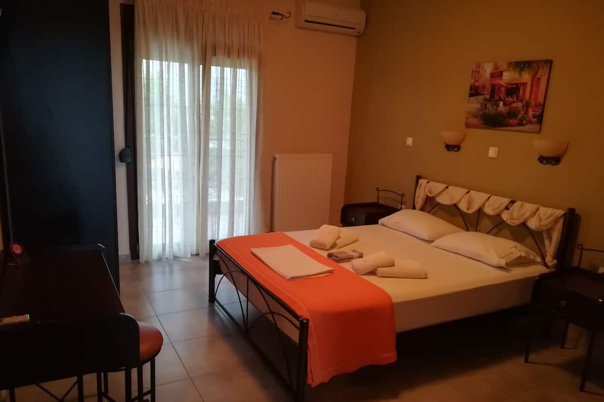 A hotel room with a bed, a desk, and a chair.