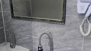 A bathroom with two sinks, a mirror, and a hand dryer.