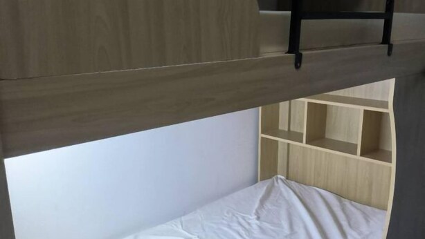 A bunk bed with a wooden frame and a white mattress.