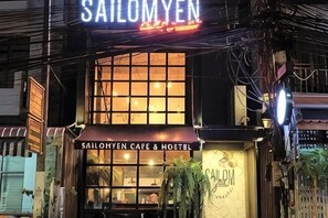 A building with a sign reading 'Sailomyen Cafe & Hostel' and a large window. - Sailomyen Cafe and Hostel (Vientiane)