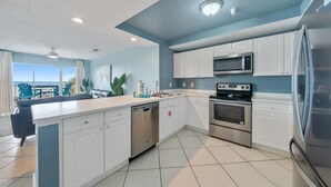 A modern kitchen with white cabinets, stainless steel appliances, and a large island. - Premier Gulf Views • Private Balcony • Freshly Updated | Amalfi 303A (Miramar Beach)