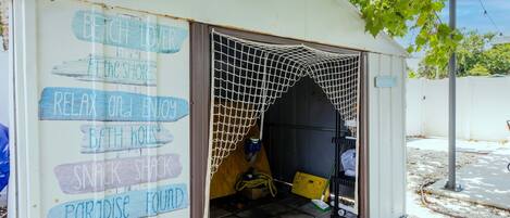 A small, open-sided structure with a netted entrance, labeled with various amenities such as a beach, a snack shack, and a paradise found.