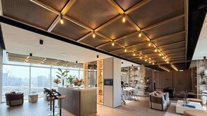A modern interior with a bar area, seating, and a view of the city. - Stylish Studio in Pearl House With Rooftop Pool (Dubai)