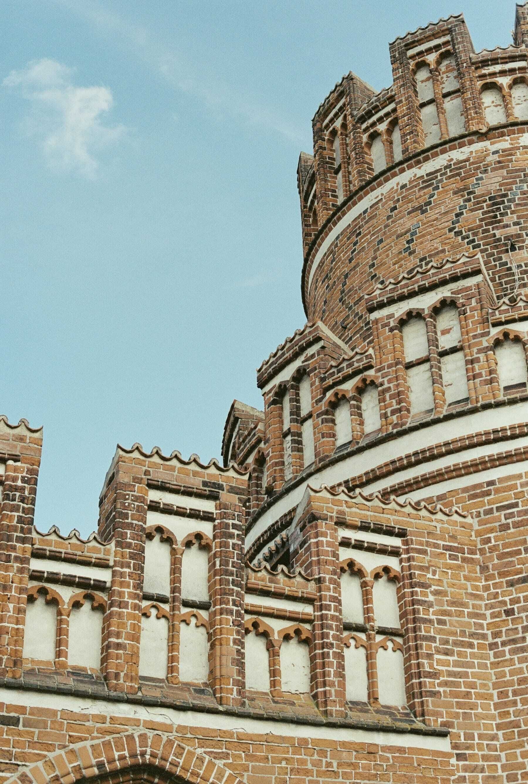 Ein historisches Gebäude mit einem runden Turm und Bogenfenstern.
