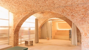 A room with a brick ceiling and arched doorways, a small table, and a window with blinds. - GARDEN FLOOR EAST: wood-burning stove and terrace to the southeast (Werben)