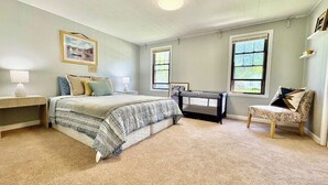 A bedroom with a bed, bedside tables, a chair, and two windows. - Spacious 5-bedroom house in lovely Amherst with Central AC, (Buffalo)