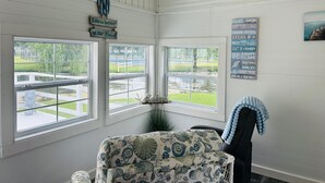 A beach-themed room with large windows, a view of a water body, and a sign with beach-related phrases. - 272 Flamingo 2 Bedroom 2 Full Baths (Surfside Beach)