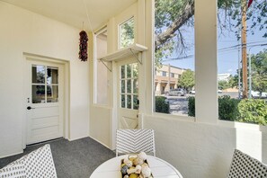 A room with a white door, a window with a view of the street, and a table with decorative items. - 1 Mi to Old Town Albuquerque! Dog-friendly Home (Albuquerque)