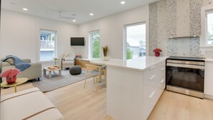 A modern kitchen with white cabinetry, a built-in oven, and a large window. - Walk to Gulf: Charming Santa Rosa Beach Duplex! (Santa Rosa Beach)