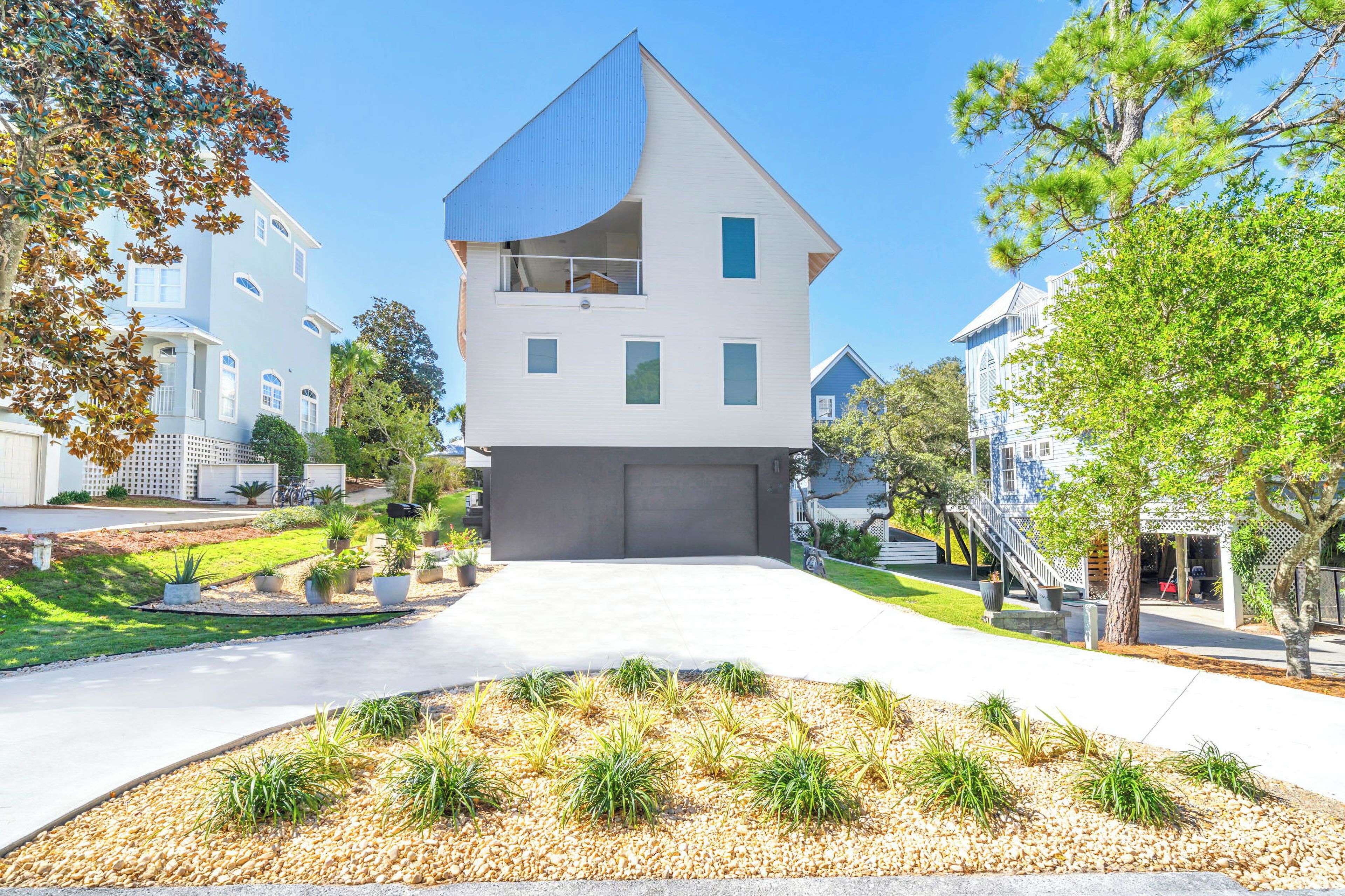 A modern two-story house with a garage, surrounded by a well-maintained lawn and trees.