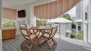 A wooden deck with a round table and chairs, a TV mounted on the wall, and a view of neighboring houses. - Stroll to Shore, Modern Santa Rosa Beach Duplex! (Santa Rosa Beach)