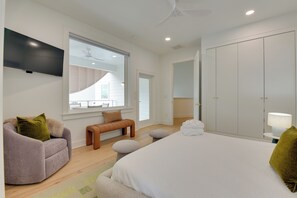 A modern bedroom with a large bed, a sofa, a bench, and a wardrobe. - Stroll to Shore, Modern Santa Rosa Beach Duplex! (Santa Rosa Beach)