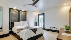 A bedroom with a bed, a ceiling fan, a window with blinds, a nightstand, and a potted plant. - Walk to Tower Grove Park: St Louis Getaway (St. Louis)