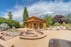A wooden cabin with a stone fire pit and outdoor seating. - 1/2 Mi to Airport Mesa! Hot Tub Haven w/ Mtn Views (Sedona)