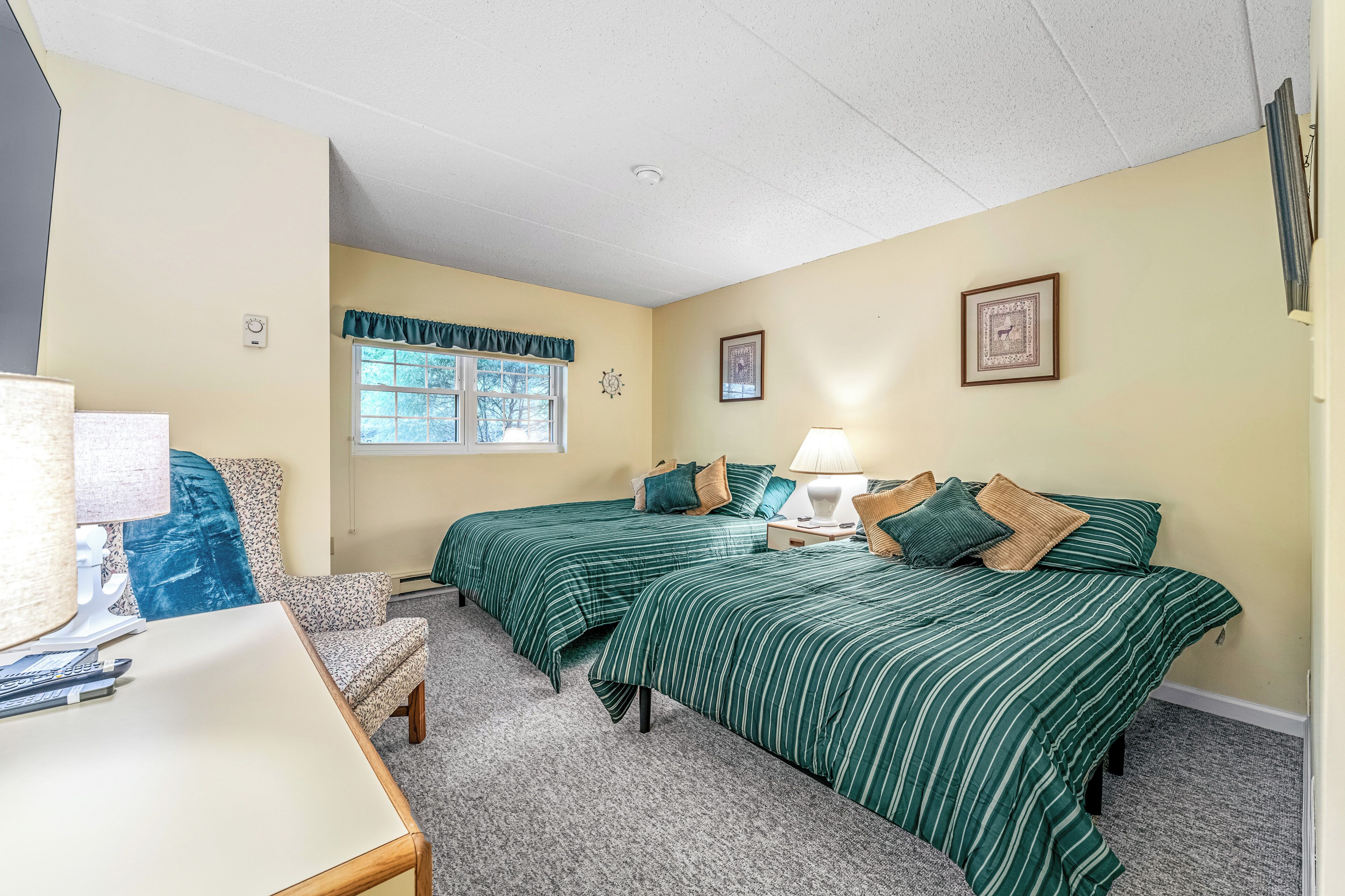 Une chambre avec deux lits, un bureau et une chaise.