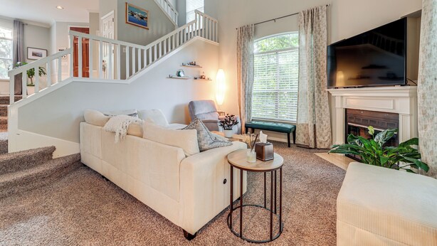 A spacious living room with a staircase, a fireplace, and a television. - Family Home w/ Deck: 12 Mi to Downtown Nashville! (Nashville)