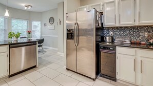 A modern kitchen with stainless steel appliances, white cabinetry, and a tiled backsplash. - Family Home w/ Deck: 12 Mi to Downtown Nashville! (Nashville)