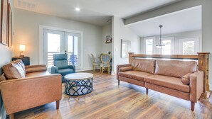 A spacious living room with a brown leather sofa, a round coffee table, and a blue patterned side table. - College Hub 1 Mi to Dtwn: Greensboro Group Escape (Greensboro)