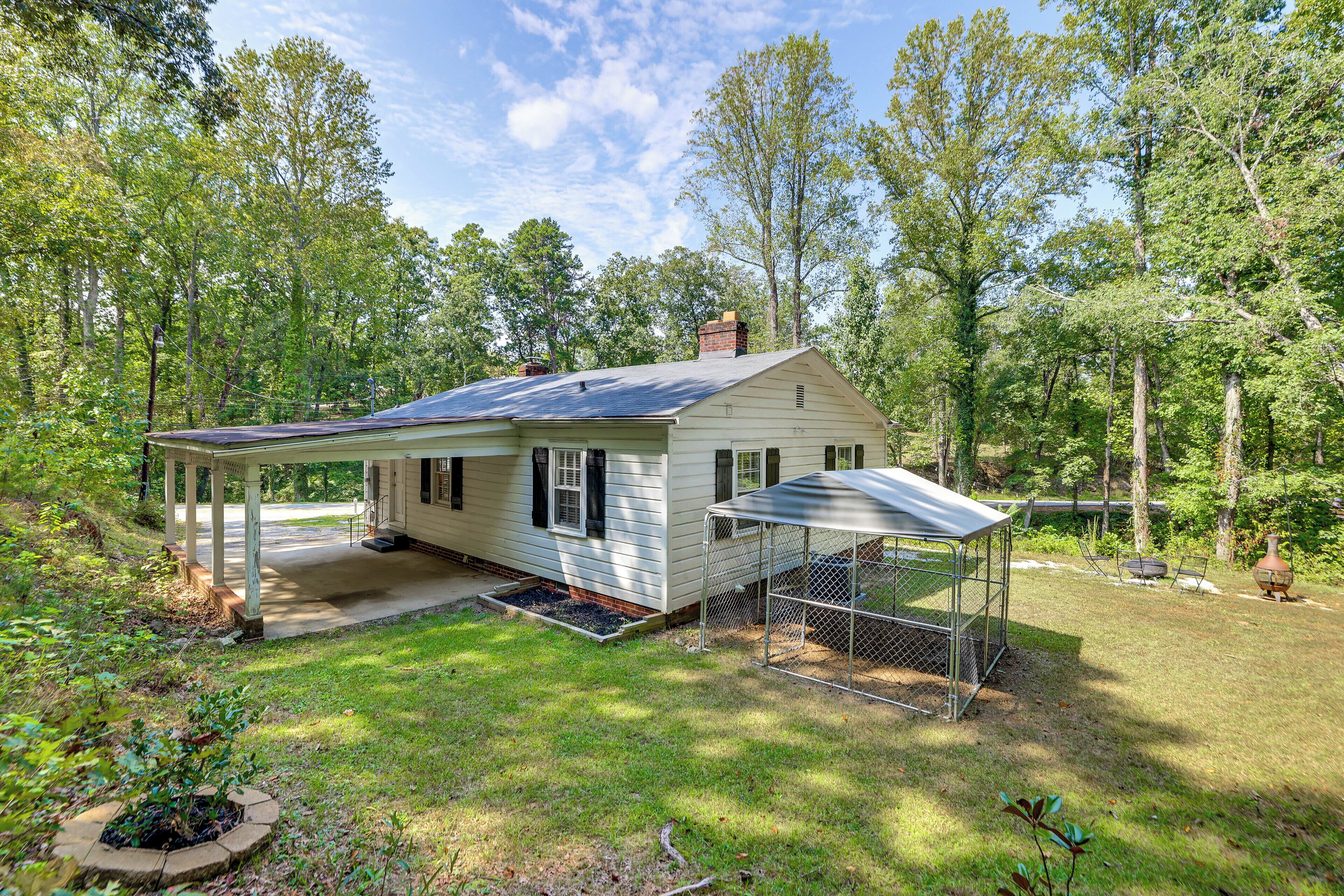 A single-story house with a covered porch and a fenced yard.