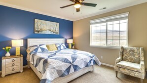 A bedroom with a bed, nightstands, a chair, a ceiling fan, a window, and a painting on the wall. - 6 Mi to Dtwn Reno: Mtn-view Retreat w/ Fireplace! (Reno)