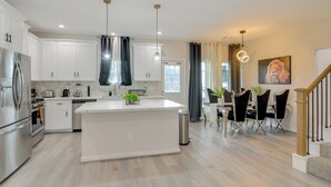 A modern kitchen with white cabinets, stainless steel appliances, and a large island. - 10 Mi to Downtown Houston: Family Home w/ Yard (Houston)