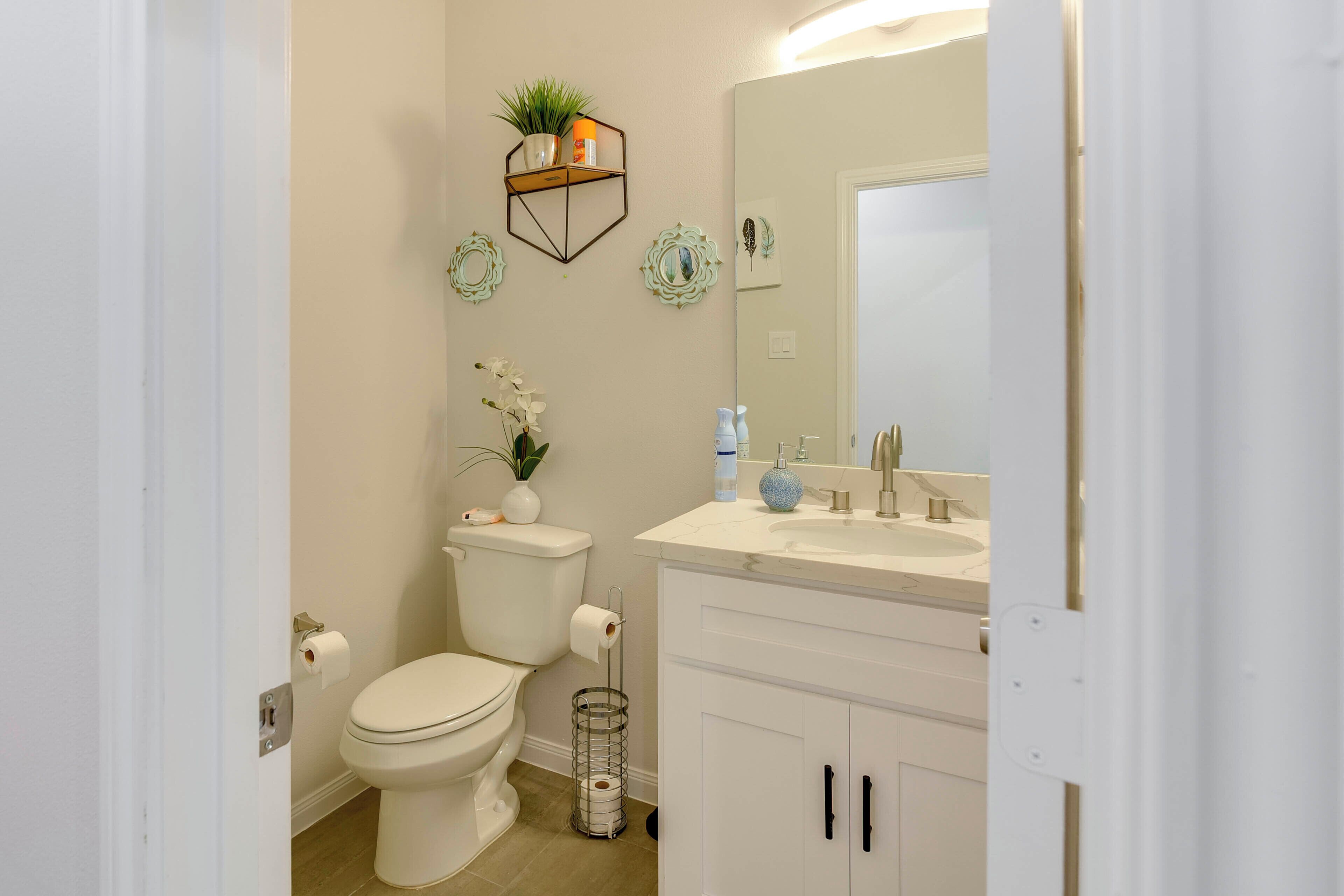 A modern bathroom with a toilet, sink, and cabinet.