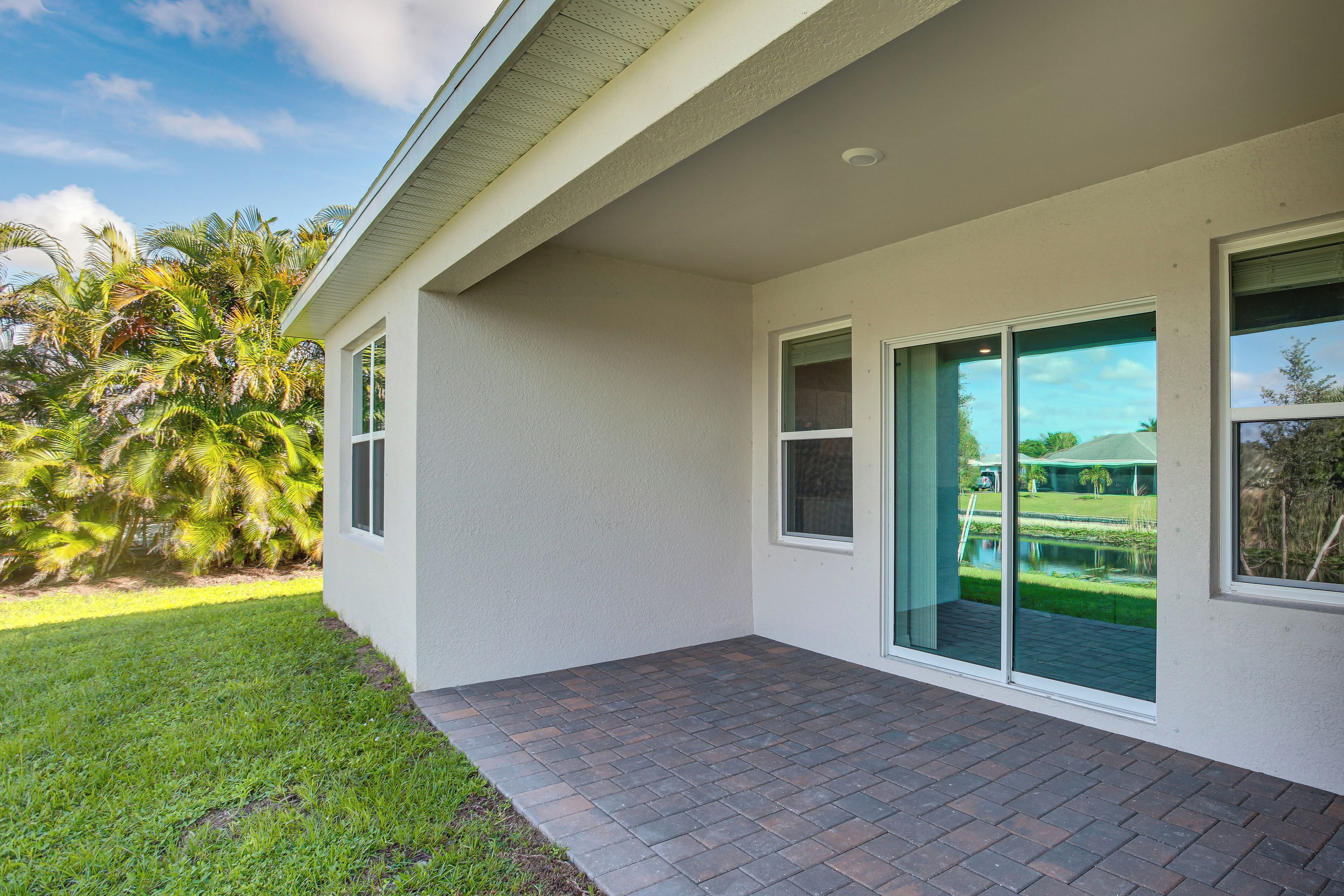 Una casa moderna con patio, ventanas amplias y vista a un campo de golf.