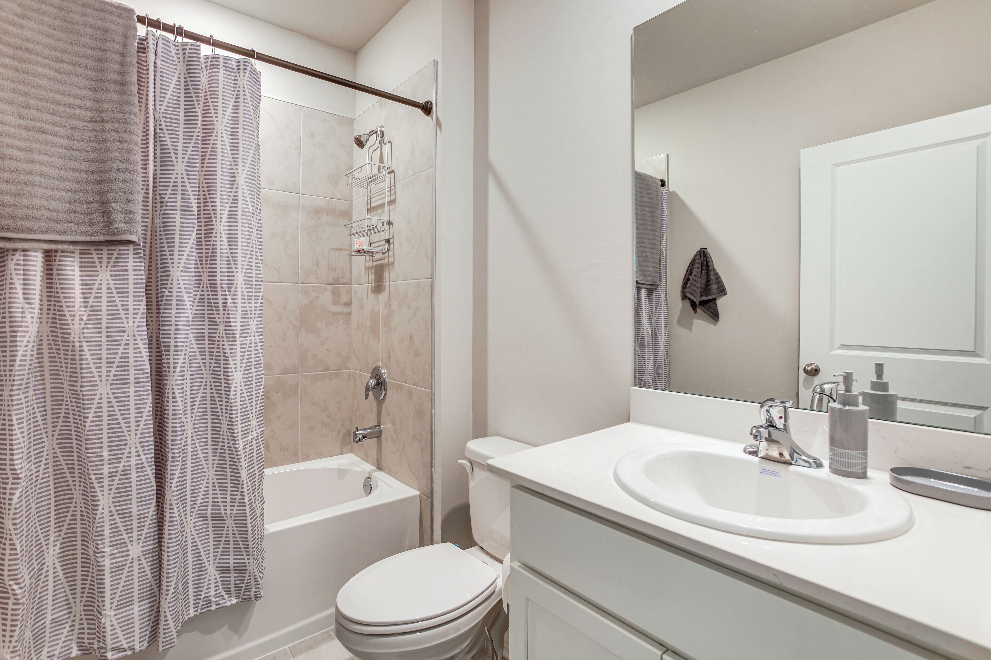 A bathroom with a bathtub, toilet, and sink.