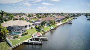 A residential area with a canal, houses, and a dock.