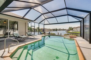 Una piscina cubierta al aire libre con vista a un lago y edificios a la distancia.