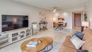 Ein Wohnzimmer mit Fernseher, Sofa, Couchtisch und Essbereich.