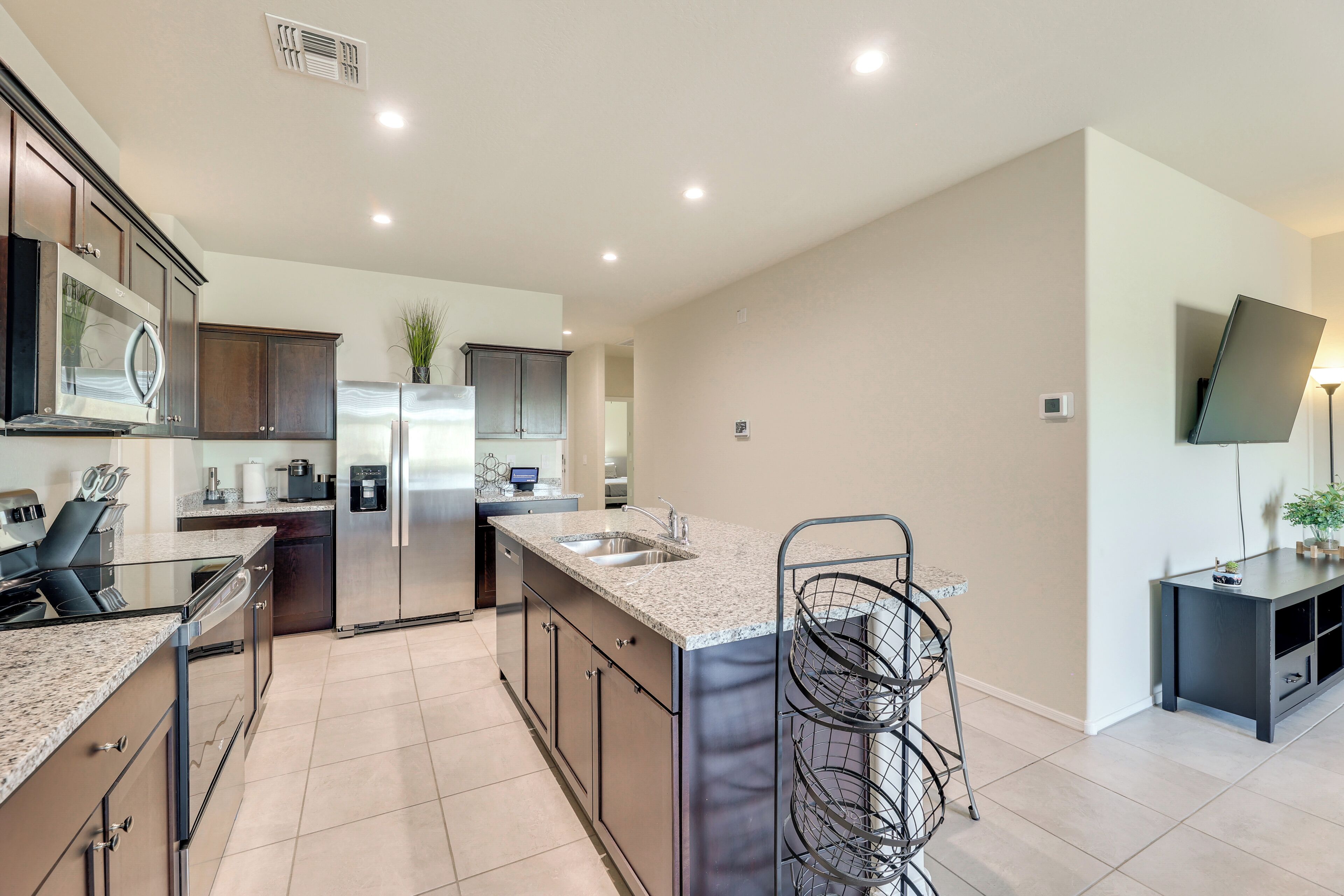 A modern kitchen with stainless steel appliances, a granite countertop, and a built-in island.