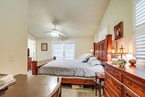 A bedroom with a bed, wooden dresser, desk, and a ceiling fan. - Walkable Miracle Mile Retreat w/ Peaceful Patio (Stockton)